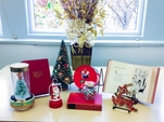Display Of Christmas Themed Books, Decorations, And Small Tabletop Christmas Trees