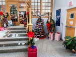Link To Facebook Page For The Pop Up Shop, Image: Pop Up Shop Entrance, Book Tree With Star And Lights, Library Mule With Bows And Garland, Decorated Gift Boxes On Stairs, Bannisters Wrapped With Garland, Lights, And Bows