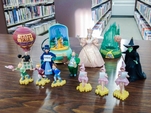 Collection Of The Wizard Of Oz Ornaments Displayed On A Table