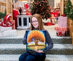 Jenna Kapral Sitting Holding Her Painting On The Steps To The Library&#8217;s Community Room